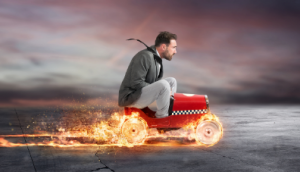 Man riding a mini car with flaming wheels signifying business development momentum.