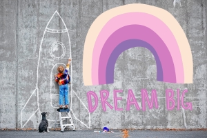 Image of a rainbow against a cement wall with text "Dream Big"